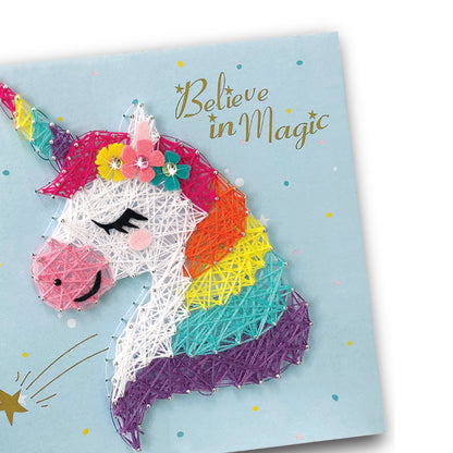 Glowing light-up unicorn string art displayed in dark room